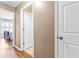 Neutral hallway showcasing hardwood floors and doors to bedrooms and bathrooms at 603 San Pedro Dr, Lady Lake, FL 32159