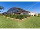 Landscaped backyard with screened-in pool and patio at 11038 Se 170Th Lane Rd, Summerfield, FL 34491