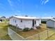 White single-wide mobile home with fenced yard at 1559 Nassau Cir, Tavares, FL 32778