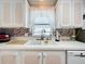 White cabinets and double sink in this updated kitchen at 1559 Nassau Cir, Tavares, FL 32778