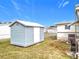 Blue storage shed with white door in backyard at 1559 Nassau Cir, Tavares, FL 32778