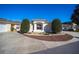 Exterior view of a single-story house with a circular driveway and manicured landscaping at 17113 Se 78Th Larchmont Ct, The Villages, FL 32162