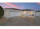 Front view of a single-story house with a two-car garage and landscaped yard at 17113 Se 78Th Larchmont Ct, The Villages, FL 32162