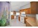Bright kitchen with wood cabinets, white appliances, and tile floor at 17113 Se 78Th Larchmont Ct, The Villages, FL 32162
