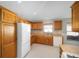 Kitchen with wood cabinets, white appliances, and tile floor at 17113 Se 78Th Larchmont Ct, The Villages, FL 32162