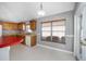 Kitchen with wood cabinets, red countertop, and window at 17113 Se 78Th Larchmont Ct, The Villages, FL 32162