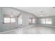 Spacious living room with vaulted ceilings, neutral walls, and large windows at 17113 Se 78Th Larchmont Ct, The Villages, FL 32162