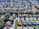 Wide aerial view showcasing the property in its residential neighborhood, with mature trees and manicured lawns at 17242 Se 94Th Coults Cir, The Villages, FL 32162