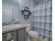 Bathroom with gray vanity, shower, and striped curtain at 17242 Se 94Th Coults Cir, The Villages, FL 32162