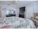 A spacious bedroom with a ceiling fan and large TV, features a comfortable bed and stylish dresser, all in soft light at 17242 Se 94Th Coults Cir, The Villages, FL 32162