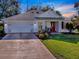 Single-story home with white siding, gray roof, and a red front door at 17242 Se 94Th Coults Cir, The Villages, FL 32162