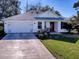 Single-story house with attached garage and red front door at 17242 Se 94Th Coults Cir, The Villages, FL 32162