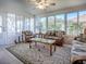 Bright sunroom with large windows, wicker furniture with patterned cushions, a ceiling fan, and a patterned area rug at 17242 Se 94Th Coults Cir, The Villages, FL 32162