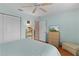 Bedroom with dresser, ceiling fan, and view into another room at 17466 Se 75Th Coachman Ct, The Villages, FL 32162