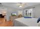 Bedroom with hardwood floors, ceiling fan, and view of living room at 17466 Se 75Th Coachman Ct, The Villages, FL 32162
