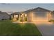 Tan house with a garage and landscaped lawn at 17466 Se 75Th Coachman Ct, The Villages, FL 32162