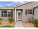 Front entrance with a white door and landscaping at 17466 Se 75Th Coachman Ct, The Villages, FL 32162