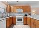 Oak kitchen cabinets, tile backsplash, and white appliances at 17466 Se 75Th Coachman Ct, The Villages, FL 32162