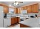 Well-equipped kitchen with oak cabinets and tile backsplash at 17466 Se 75Th Coachman Ct, The Villages, FL 32162