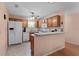Kitchen boasts oak cabinets, tile backsplash, and breakfast bar at 17466 Se 75Th Coachman Ct, The Villages, FL 32162