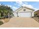 House exterior showcasing a two-car garage and landscaping at 1757 Landrum Ln, The Villages, FL 32162