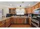 Modern kitchen with granite countertops, stainless steel appliances, and wood cabinets at 1757 Landrum Ln, The Villages, FL 32162