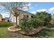Side yard view showcasing mature shrubs and a tree at 1757 Landrum Ln, The Villages, FL 32162