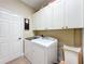 Bright laundry room with cabinets and washer/dryer at 27103 Camerons Run, Leesburg, FL 34748