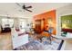 Spacious living room with an orange accent wall and view of the dining area at 27103 Camerons Run, Leesburg, FL 34748