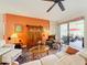 Comfortable living room with an orange accent wall and patio access at 27103 Camerons Run, Leesburg, FL 34748