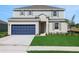 Charming two-story home with a blue garage door and well-maintained lawn at 2833 Supermarine Rd, Tavares, FL 32778