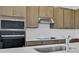 Close up of kitchen with stainless steel microwave, oven, and range hood with subway tile backsplash at 2833 Supermarine Rd, Tavares, FL 32778