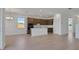 Open-concept kitchen and living room with lots of light and wood floors at 2833 Supermarine Rd, Tavares, FL 32778