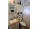 Well lit bathroom with decorative seashell decor on shelves and above cabinets at 30 Riverview Dr, Fruitland Park, FL 34731