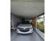 Carport with a silver car parked inside and outdoor plants nearby at 30 Riverview Dr, Fruitland Park, FL 34731