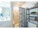 Bright bathroom featuring a walk-in shower, vanity, and modern shelving unit at 308 Santa Clara Cir, Lady Lake, FL 32159