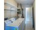 Well-lit laundry room with washer, dryer, shelving, and ample storage space at 308 Santa Clara Cir, Lady Lake, FL 32159