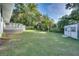Spacious backyard with lush grass, mature trees, patio deck, and storage shed at 422 W 11Th Ave, Mount Dora, FL 32757