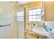 Bright bathroom with tiled shower, white sink, and window offering natural light at 422 W 11Th Ave, Mount Dora, FL 32757
