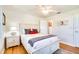 Bright bedroom with wood floors, white furniture, queen bed, ceiling fan, and neutral decor at 422 W 11Th Ave, Mount Dora, FL 32757