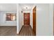 Hallway with wood-look flooring leading to a dark brown door and a closet at 5640 Se 21St Ln, Ocala, FL 34480