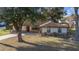 Attractive single-story home with stone accents, manicured landscaping, and a red front door at 5640 Se 21St Ln, Ocala, FL 34480