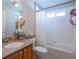 Bathroom with granite countertop, wood cabinets, and bathtub at 629 San Marino Dr, The Villages, FL 32159