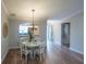 Bright dining room features a white table with four chairs and hardwood floors at 629 San Marino Dr, The Villages, FL 32159