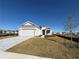 One-story house with gray siding, two-car garage, and grassy front yard at 8592 Hempstead Way, Mount Dora, FL 32757
