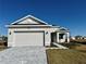 One-story home with gray siding, two-car garage, and a landscaped front yard at 8592 Hempstead Way, Mount Dora, FL 32757