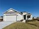 One-story home with gray siding, two-car garage, and a landscaped front yard at 8592 Hempstead Way, Mount Dora, FL 32757