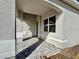 Covered front porch with gray pavers and arched entryway at 8592 Hempstead Way, Mount Dora, FL 32757