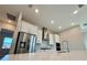 Modern kitchen features stainless steel appliances and a large quartz island at 8592 Hempstead Way, Mount Dora, FL 32757