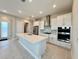 Bright kitchen boasts white cabinets, stainless steel appliances, and a spacious island at 8592 Hempstead Way, Mount Dora, FL 32757